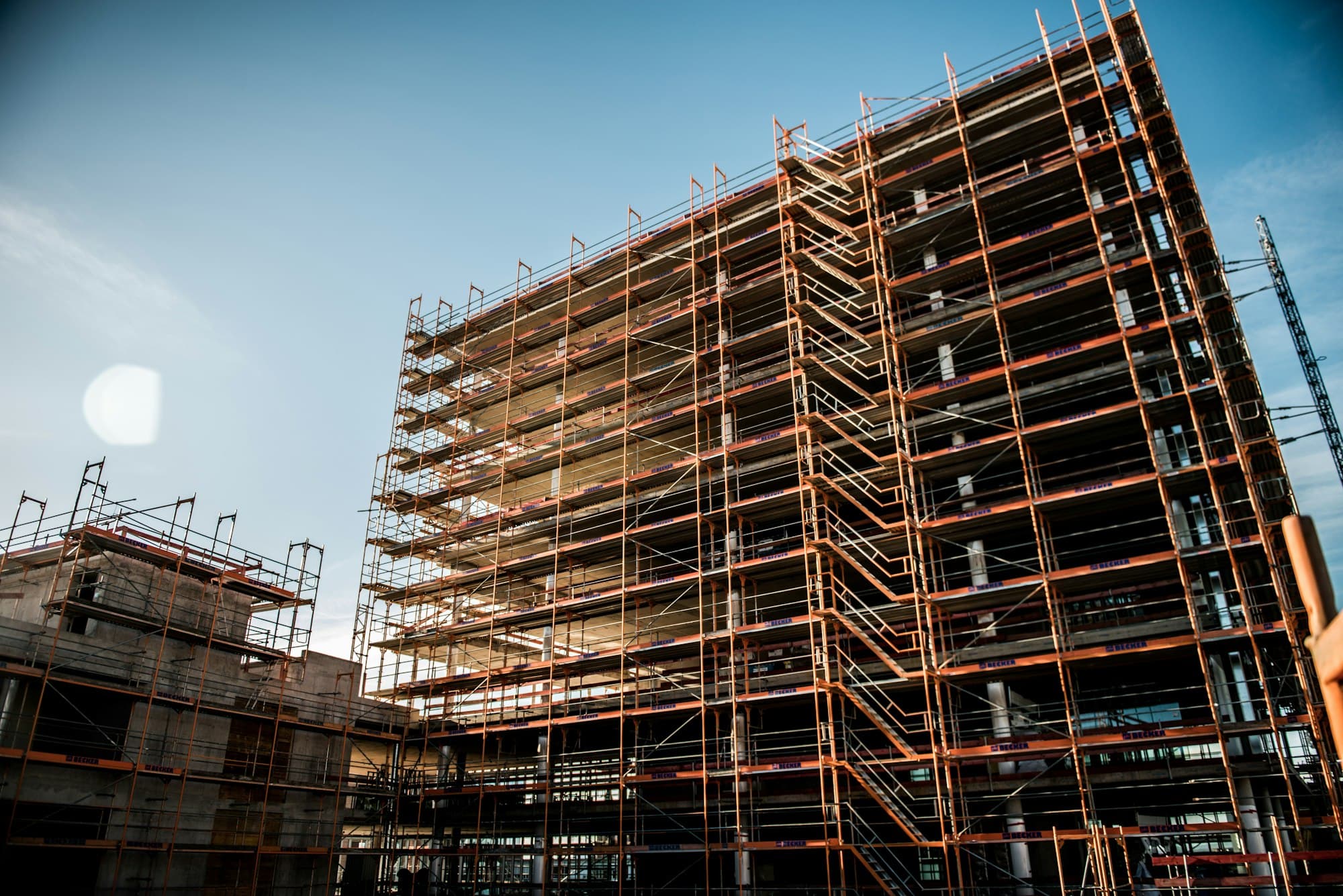 Gedung bertingkat yang dipasangi scaffolding rangka oranye
